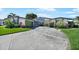 A lovely single-story home has a well-manicured lawn, lush landscaping, and a circular driveway at 955 Don Juan Ct, Punta Gorda, FL 33950