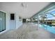 Spacious, covered patio with brick flooring and a screened enclosure overlooks a sparkling pool and canal at 955 Don Juan Ct, Punta Gorda, FL 33950