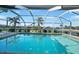Sparkling pool with screened enclosure, offering clear views of the tranquil canal and tropical landscaping at 955 Don Juan Ct, Punta Gorda, FL 33950