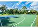 A view of the basketball court surrounded by lush trees and a green fence at 1065 Harbour Glen Pl, Punta Gorda, FL 33983