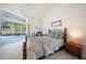 Vaulted primary bedroom featuring a king bed and sliding glass doors to pool at 1065 Harbour Glen Pl, Punta Gorda, FL 33983