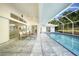 Spacious patio with seating area overlooking the sparkling pool in the screened enclosure at 1065 Harbour Glen Pl, Punta Gorda, FL 33983