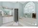 Luxurious bathroom featuring a soaking tub, separate glass shower, granite vanity, and stylish fixtures at 1311 Pine Siskin Dr, Punta Gorda, FL 33950