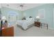 Bedroom with a queen bed, ceiling fan, a window with shutters and a dark wood desk at 1311 Pine Siskin Dr, Punta Gorda, FL 33950