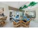 Charming dining area with glass table, wicker chairs, and views of the pool area, all reflected in mirrored walls at 1311 Pine Siskin Dr, Punta Gorda, FL 33950