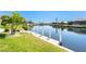 Scenic view of a canal with a private dock and manicured landscaping under a clear sky at 1311 Pine Siskin Dr, Punta Gorda, FL 33950