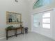 Bright foyer with tiled floor, double doors and a decorative mirror and console table at 1311 Pine Siskin Dr, Punta Gorda, FL 33950