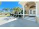 Inviting home featuring manicured bushes, palm trees, and a grand covered entryway with white columns at 1311 Pine Siskin Dr, Punta Gorda, FL 33950