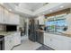 Kitchen with white cabinetry, stainless steel appliances, a breakfast bar, and a view of the water at 1311 Pine Siskin Dr, Punta Gorda, FL 33950