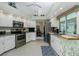 Bright kitchen with white cabinets, stainless steel appliances, granite countertops and breakfast nook at 1311 Pine Siskin Dr, Punta Gorda, FL 33950