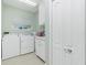 Well-lit laundry room features washer, dryer, storage cabinets, and light green walls at 1311 Pine Siskin Dr, Punta Gorda, FL 33950