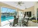 Large covered lanai with lounge chairs, dining set, grill, and views of the canal and pool at 1311 Pine Siskin Dr, Punta Gorda, FL 33950