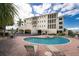 Lovely building exterior featuring a community pool, covered parking, and lush tropical landscaping at 1340 Rock Dove Ct # 132, Punta Gorda, FL 33950