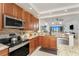 Open concept kitchen with stainless appliances, granite counters, tile backsplash, and a lovely view of the living area at 1340 Rock Dove Ct # 132, Punta Gorda, FL 33950