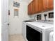 Bright laundry room with washer, dryer, storage cabinets, and cute decor at 1340 Rock Dove Ct # 132, Punta Gorda, FL 33950