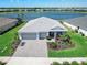 Aerial view of a single-story home with a three-car garage in a lakeside community, surrounded by lush green lawns at 16064 Shoreline Dr, Punta Gorda, FL 33982
