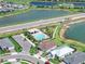 Community clubhouse featuring pool, parking, and surrounding lush landscaping and ponds at 16064 Shoreline Dr, Punta Gorda, FL 33982