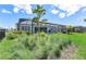 View of the home's outdoor living space featuring a screened-in lanai and manicured lawn at 16064 Shoreline Dr, Punta Gorda, FL 33982