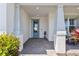 Inviting entryway featuring a covered porch, brick flooring, and a stylish blue door at 16064 Shoreline Dr, Punta Gorda, FL 33982