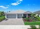 Charming single-story home with a three-car garage and meticulously maintained landscaping with palm trees at 16064 Shoreline Dr, Punta Gorda, FL 33982