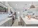 Stylish kitchen with gray cabinets, stainless steel appliances, and a spacious quartz island, offering modern convenience at 16064 Shoreline Dr, Punta Gorda, FL 33982