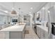 Modern kitchen featuring a large quartz island, gray cabinets, stainless steel appliances, and pendant lighting at 16064 Shoreline Dr, Punta Gorda, FL 33982