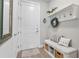 Mudroom area with bench seating, storage basket, wreath, and coat hooks for organization at 16064 Shoreline Dr, Punta Gorda, FL 33982