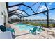 Relaxing screened-in pool area with water views, spa, patio furniture, and sunny skies at 16064 Shoreline Dr, Punta Gorda, FL 33982