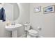 Powder room with pedestal sink, modern fixtures, and wood look tile floors at 16064 Shoreline Dr, Punta Gorda, FL 33982