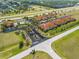 Beautiful aerial view of a housing community with terracotta roofs, palm trees, and a community pool at 16308 Sunset Palms Blvd # 1702, Punta Gorda, FL 33955