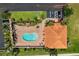 Overhead shot of a pool and patio area next to a clubhouse with palm trees and landscaping at 16308 Sunset Palms Blvd # 1702, Punta Gorda, FL 33955