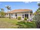 Well-maintained backyard with lush green grass, mature landscaping, and a charming screened-in porch area at 16308 Sunset Palms Blvd # 1702, Punta Gorda, FL 33955