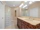 Bathroom featuring double sinks, a glass block shower and neutral tile floors at 16308 Sunset Palms Blvd # 1702, Punta Gorda, FL 33955