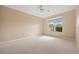 Neutral bedroom featuring neutral carpet, large window and ceiling fan at 16308 Sunset Palms Blvd # 1702, Punta Gorda, FL 33955
