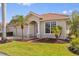 Charming home featuring a well-manicured lawn, a two-car garage, and lovely landscaping with palm trees at 16308 Sunset Palms Blvd # 1702, Punta Gorda, FL 33955
