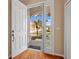 Welcoming entryway showcasing an open white door with a view of the well-landscaped front yard at 16308 Sunset Palms Blvd # 1702, Punta Gorda, FL 33955