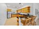 Bright kitchen featuring wood cabinets, stainless steel refrigerator, tile flooring, and bar seating at 16308 Sunset Palms Blvd # 1702, Punta Gorda, FL 33955