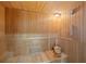 Interior view of a well-maintained wooden sauna, including a thermometer, wall light, and bucket at 16308 Sunset Palms Blvd # 1702, Punta Gorda, FL 33955