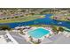 Gorgeous aerial view showcasing a large community pool with lounge chairs and cabanas for relaxation at 1848 Birmingham Blvd, Port Charlotte, FL 33980