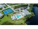 Aerial shot of community pool, tennis courts, clubhouse, and parking near a pond at 2060 Willow Hammock Cir # 207, Punta Gorda, FL 33983