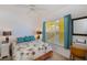 Bright bedroom with palm-tree bedding, blue pillows, fan, and natural light from the window at 2060 Willow Hammock Cir # 207, Punta Gorda, FL 33983
