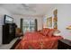 Bedroom with large window letting in natural light, ceiling fan, dresser with television, and decorative wall art at 2060 Willow Hammock Cir # 207, Punta Gorda, FL 33983