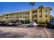 Exterior shot of a yellow condominium complex with balconies, stairs, and covered parking at 2060 Willow Hammock Cir # 207, Punta Gorda, FL 33983
