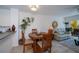 Dining area flows to living room with modern light fixture, wood table and chairs, and views to the lanai at 2060 Willow Hammock Cir # 207, Punta Gorda, FL 33983