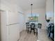 Cozy breakfast nook with black metal table and chairs next to the bright white refrigerator, cabinets and pantry at 2060 Willow Hammock Cir # 207, Punta Gorda, FL 33983
