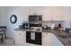 Well-lit kitchen with white cabinets, black appliances, and ample counter space at 2060 Willow Hammock Cir # 207, Punta Gorda, FL 33983