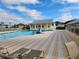 Community pool area featuring comfortable lounge chairs and a clubhouse in a beautiful tropical setting at 2060 Willow Hammock Cir # 207, Punta Gorda, FL 33983
