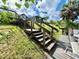 Charming backyard featuring wooden stairs and deck leading to lush green landscaping at 2095 Ellery St, Port Charlotte, FL 33952