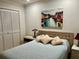 Bedroom featuring a queen bed with bedside tables, wall art and closet with shutter doors at 2095 Ellery St, Port Charlotte, FL 33952