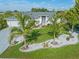 Beautiful single-story home with a manicured lawn, palm trees, and decorative rock landscaping at 2095 Ellery St, Port Charlotte, FL 33952
